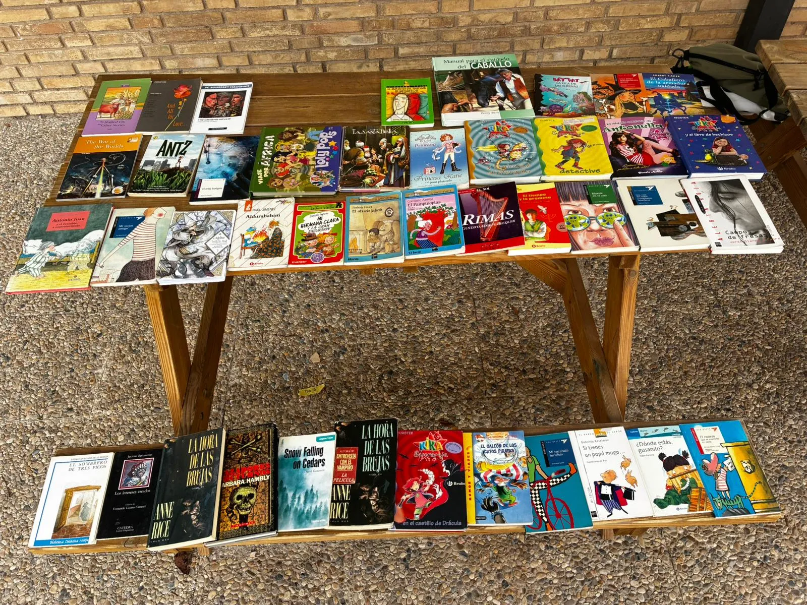 Niñas y niños eligiendo libros en el mercadillo